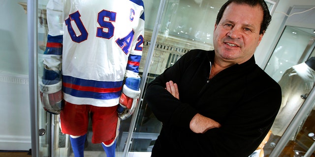 Mike Eruzione, captain of the 1980 gold medal-winning U.S. Olympic ice hockey team, posed next to the jersey and uniform he wore when the U.S. defeated the Soviet Union in what is known as the "Miracle on Ice" at Heritage Auctions in New York City in 2013. (REUTERS/Mike Segar)