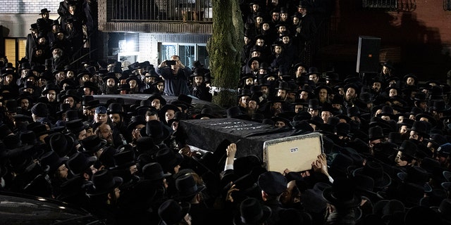 Orthodox Jewish men carry Moshe Deutsch's casket outside a Brooklyn synagogue following his funeral on Wednesday in New York. Deutsch was one of the victims killed in Tuesday's shooting in Jersey City, N.J.