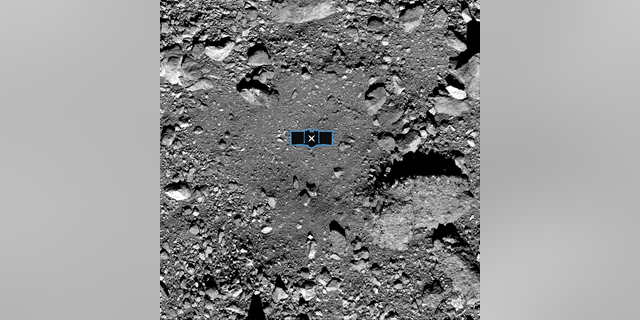 This image released by NASA shows sample site Nightingale, OSIRIS-REx’s primary sample collection site on asteroid Bennu. The image is overlaid with a graphic of the OSIRIS-REx spacecraft to illustrate the scale of the site.
