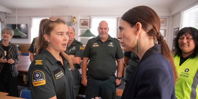 New Zealand's Prime Minister Jacinda Ardern, right, talks with first responders in Whakatane, New Zealand, Tuesday, Dec. 10, 2019.