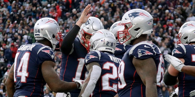 New England Patriots quarterback Tom Brady, rear, congratulates running back James White, center, on his touchdown against the Miami Dolphins in the second half of an NFL football game, Sunday, Dec. 29, 2019, in Foxborough, Mass. (AP Photo/Elise Amendola)