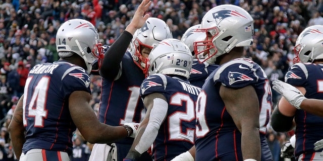New England Patriots quarterback Tom Brady, rear, congratulates running back James White, center, on his touchdown against the Miami Dolphins in the second half of an NFL football game, Sunday, Dec. 29, 2019, in Foxborough, Mass. (AP Photo/Elise Amendola)
