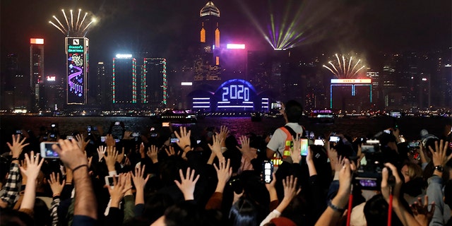 Protesters hold up their hands to symbolize the five demands of the pro-democracy movement as New Year's fireworks light up the sky during a demonstration in Hong Kong, Wednesday, Jan. 1, 2020. (Associated Press)