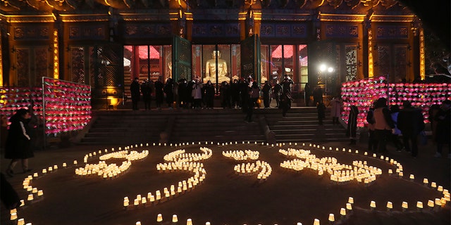 Buddhists light candles to form letters meaning, "Best wishes for a Happy New Year," during New Year celebrations at Jogyesa Buddhist temple in Seoul, South Korea, Wednesday, Jan. 1, 2020. (Associated Press)
