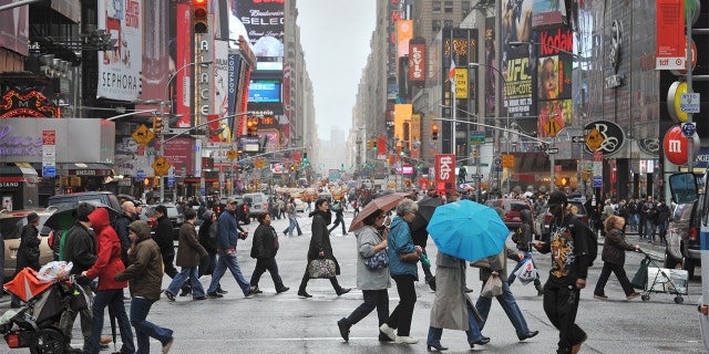 Crowds of New Yorkers and visitors cross the street in Times Square. [FILE) 