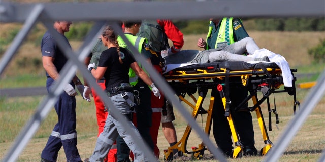 Emergency services attend to an injured person arriving at the Whakatane Airfield after the volcanic eruption Monday, Dec. 9, 2019, on White Island, New Zealand. (Alan Gibson/New Zealand Herald via AP)