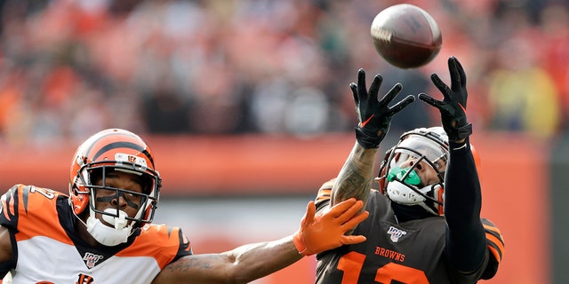 Cleveland Browns wide receiver Odell Beckham Jr. (13) can't hold onto the ball under pressure from Cincinnati Bengals cornerback William Jackson (22) during the first half of an NFL football game, Sunday, Dec. 8, 2019, in Cleveland. (AP Photo/Ron Schwane)