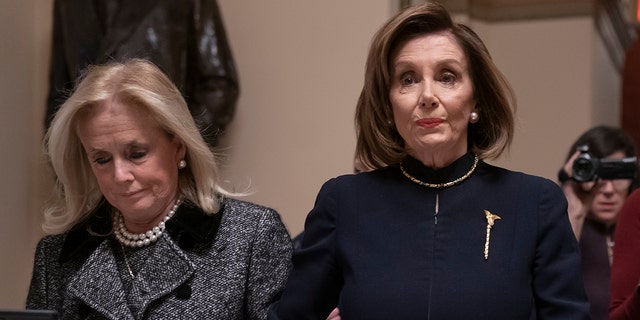 Speaker of the House Nancy Pelosi, D-Calif., holds hands with Rep. Debbie Dingell, D-Mich., as they walk to the chamber where the Democratic-controlled House of Representatives begins a day of debate on the impeachments charges against President Donald Trump for abuse of power and obstruction of Congress, at the Capitol in Washington, Wednesday, Dec. 18, 2019. (AP Photo/J. Scott Applewhite)