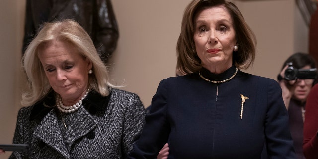 Speaker of the House Nancy Pelosi, D-Calif., holds hands with Rep. Debbie Dingell, D-Mich., as they walk to the chamber where the Democratic-controlled House of Representatives begins a day of debate on the impeachments charges against President Donald Trump for abuse of power and obstruction of Congress, at the Capitol in Washington, Wednesday, Dec. 18, 2019. (AP Photo/J. Scott Applewhite)