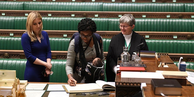 Britain's Conservative MP Kemi Badenoch attends a swearing-in ceremony in London while carrying her child. 