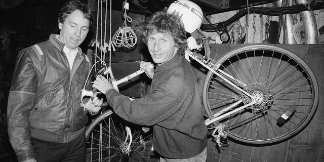 FILE - In this May 16, 1985, file photo, actor John Ritter, left, checks out the bicycle of fellow actor Rene Auberjonois, center, backstage at the Eugene O'Neill Theatre in New York following a performance of the Broadway musical, "Big River: The Adventures of Huckleberry Finn."
