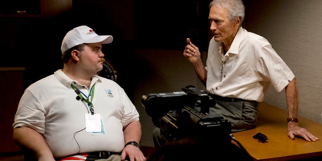 In this image released by Warner Bros. Pictures, director Clint Eastwood speaks with actor Paul Walter Hauser as they work during the filming of the movie 