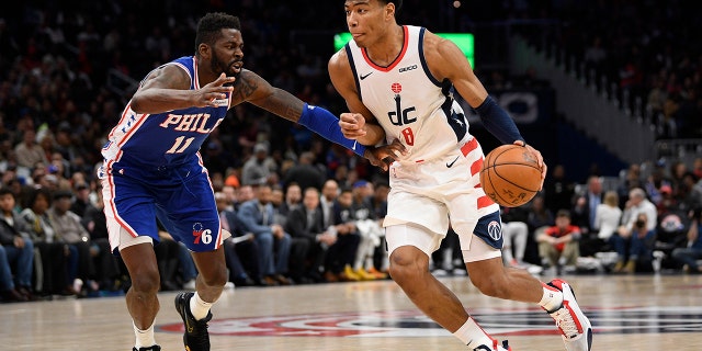 Washington Wizards forward Rui Hachimura (8), of Japan, dribbles the ball as he is defended by Philadelphia 76ers forward James Ennis III (11) during the second half of an NBA basketball game, Thursday, Dec. 5, 2019, in Washington. The Wizards won 119-113. (AP Photo/Nick Wass)