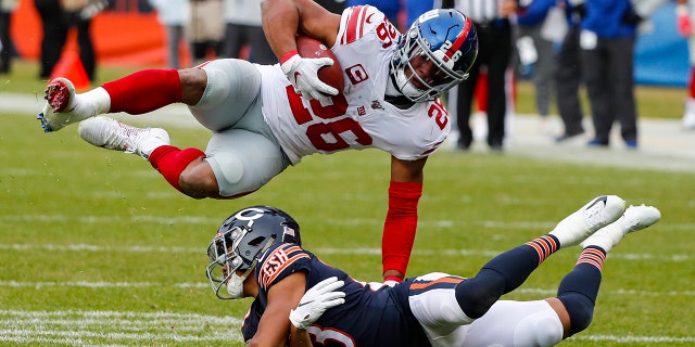 New York Giants running back Saquon Barkley (26) flips over Chicago Bears cornerback Kyle Fuller (23) during the second half of an NFL football game in Chicago, Sunday, Nov. 24, 2019. (AP Photo/Charles Rex Arbogast)