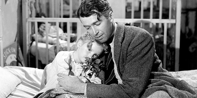 American actors James Stewart (1908 - 1997), as George Bailey, and Karolyn Grimes as his daughter Zuzu, in a scene from 