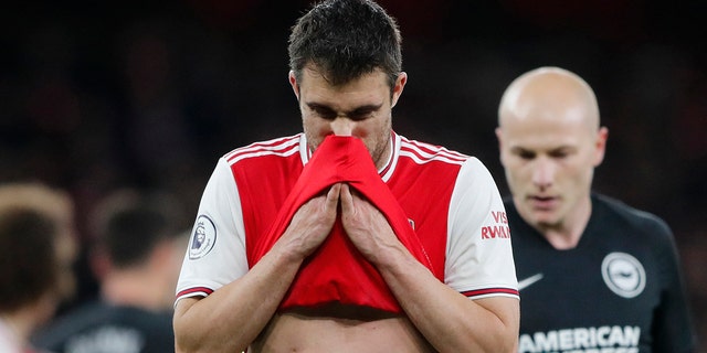 Arsenal's Sokratis Papastathopoulos wipes his face during the English Premier League soccer match between Arsenal and Brighton, at the Emirates Stadium in London, Thursday, Dec. 5, 2019. (AP Photo/Frank Augstein)