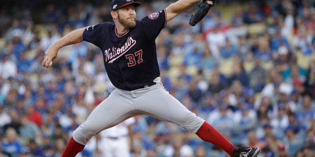 FILE - In this Oct. 9, 2019, file photo, Washington Nationals starting pitcher Stephen Strasburg throws to a Los Angeles Dodgers batter during the first inning in Game 5 of a baseball National League Division Series, in Los Angeles. World Series MVP Stephen Strasburg is staying with the Washington Nationals. The right-hander has agreed to a record $245 million, seven-year contract, a person familiar with the negotiations told The Associated Press on Monday, Dec. 9, 2019. The person spoke on condition of anonymity at baseball's annual winter meetings because the agreement had not been announced. (AP Photo/Marcio Jose Sanchez, File)