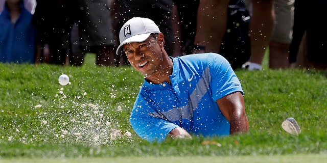FILE - In this Thursday, Aug. 15, 2019 file photo, Tiger Woods hits from a sand trap on the fourth hole during the first round of the BMW Championship golf tournament at Medinah Country Club in Medinah, Ill. Woods is in the Bahamas this week as a player and a host, and in Australia next week as a player and Presidents Cup captain. (AP Photo/Nam Y. Huh, File)