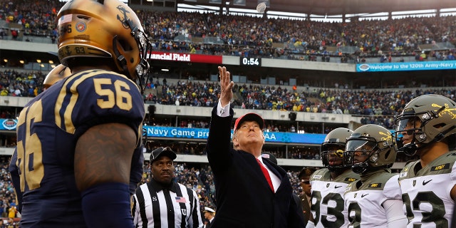 President Donald Trump throws the coin before the start of the Army-Navy college football game in Philadelphia, Saturday, Dec. 14, 2019. (AP Photo/Jacquelyn Martin)