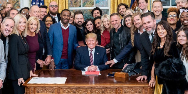 President Trump surrounded by a large group of worship leaders from across the country whom he invited to pray for him in the Oval Office Friday.