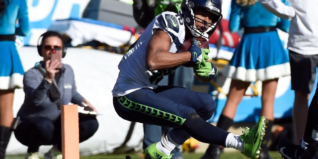 Seattle Seahawks wide receiver Tyler Lockett (16) scores a touchdown against the Carolina Panthers during the first half of an NFL football game in Charlotte, N.C., Sunday, Dec. 15, 2019. (AP Photo/Mike McCarn)