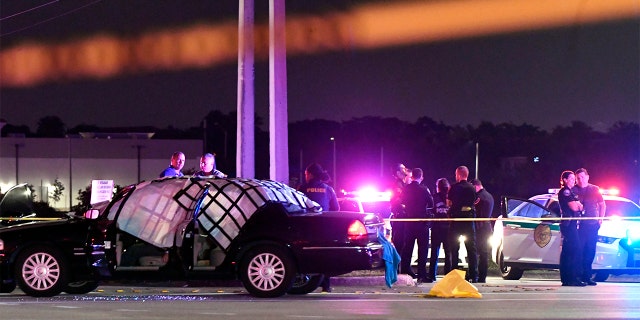 EDS NOTE: GRAPHIC CONTENT - In this Thursday, Dec. 5, 2019, photo authorities investigate the scene of a shooting in Miramar, Fla. The FBI says several people, including a UPS driver, were killed after robbers stole the driver's truck and led police on a chase that ended in gunfire at a busy South Florida intersection during rush hour. (Taimy Alvarez/South Florida Sun-Sentinel via AP)