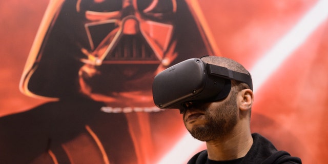 An attendee plays the 'Vader Immortal: A Star Wars VR Series