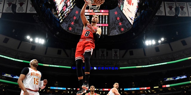 Chicago Bulls guard Zach LaVine (8) dunks the ball as Atlanta Hawks guard Vince Carter (15) stands nearby during the first half of an NBA basketball game, Wednesday, Dec. 11, 2019, in Chicago. (AP Photo/David Banks)