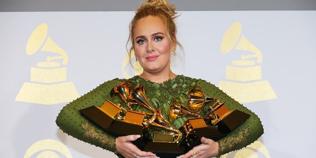 Adele holdomg the five Grammys she won including Record of the Year for "Hello" and Album of the Year for "25" in 2017.
