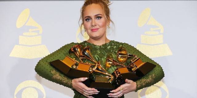 Adele holds the five Grammys she won including Record of the Year for 'Hello' and Album of the Year for '25' during the 59th Annual Grammy Awards in Los Angeles, Calif.
