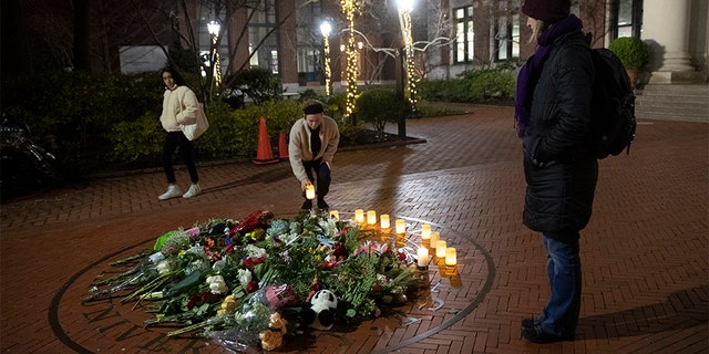 People pause and place a candle at a makeshift memorial for Tessa Majors inside the Barnard campus on Thursday. (AP)