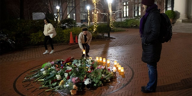 People pause and place a candle at a makeshift memorial for Tessa Majors inside the Barnard campus on Thursday.