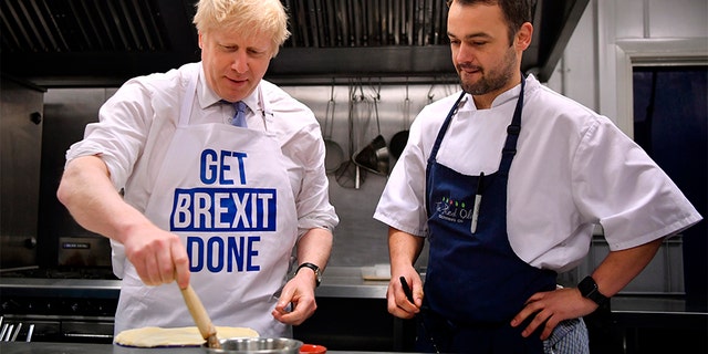 Britain's Prime Minister Boris Johnson prepares a pie at the Red Olive catering company while on the campaign trail, in Derby, England, on Wednesday. 