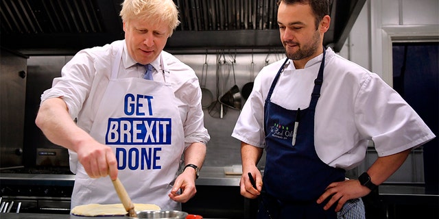 Britain's Prime Minister Boris Johnson prepares a pie at the Red Olive catering company while on the campaign trail, in Derby, England, on Wednesday.