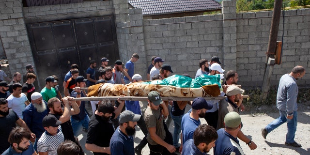 In this Aug. 29, 2019 file photo people carry the body of the victim who has been identified as Zelimkhan Khangoshvili, who was shot dead in Berlin.