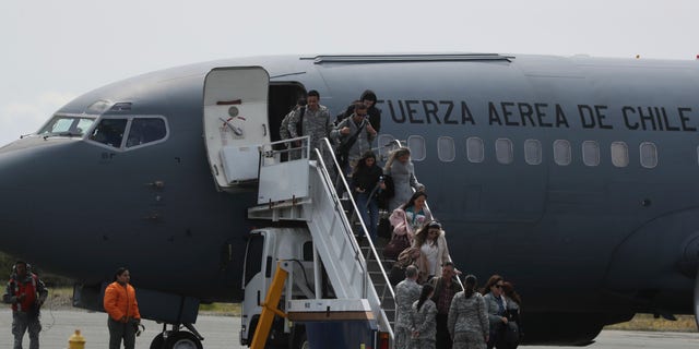 Relatives of passengers of a missing military plane arrive in a Chilean military airplane to an airbase in Punta Arenas, Chile, Wednesday, Dec. 11, 2019. (AP Photo/Fernando Llano)