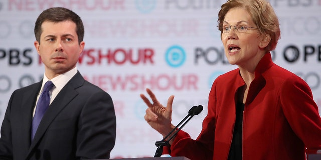 Sen. Elizabeth Warren (D-MA) speaks as former South Bend, Ind., Mayor Pete Buttigieg listens during the Democratic presidential primary debate at Loyola Marymount University on Dec. 19, 2019 in Los Angeles, Calif.