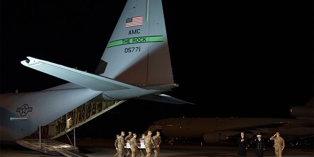 An Air Force carry team moves a transfer case containing the remains of Seaman Apprentice Cameron Scott Walters -- one of the victims of the Pensacola shooting -- on Sunday at Dover Air Force Base in Delaware. 