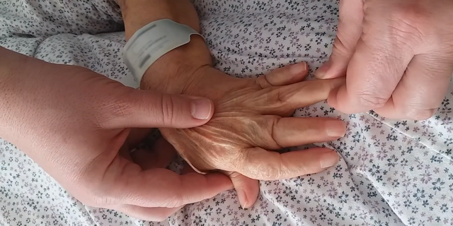 A doctor treating the woman gently pulled her finger tips to temporarily straighten her fingers.