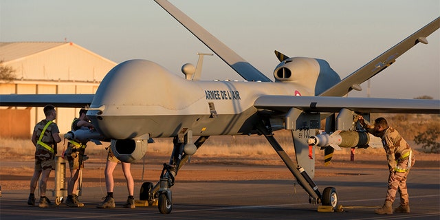 This photo provided by the French Defense Ministry communication center and taken Dec. 17 shows French soldiers loading a French Reaper drone with two GBU 12 missiles on Niamey airbase, Niger. France's defense ministry said Monday that it had carried out its first armed drone strike, killing seven Islamic extremists in central Mali over the weekend.