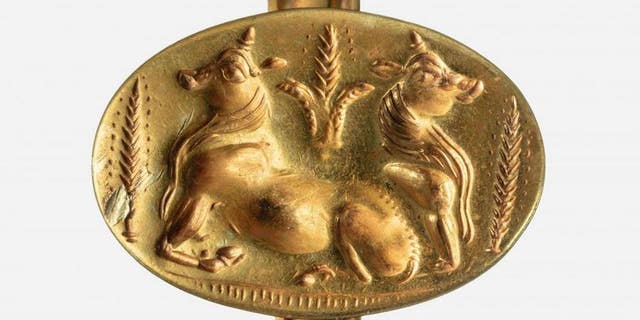A gold ring depicts bulls and barley, the first known representation of domesticated animals and agriculture in ancient Greece.