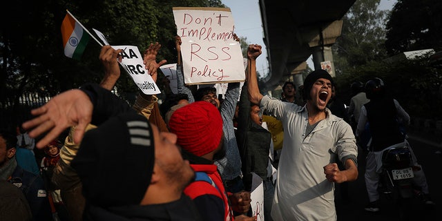 Indian students of the Jamia Millia Islamia University shout slogans as they march during a protest, in New Delhi, India, Wednesday, Dec. 18, 2019. India’s Supreme Court on Wednesday postponed hearing pleas challenging the constitutionality of the new citizenship law that has sparked opposition and massive protests across the country. (AP Photo/Altaf Qadri)