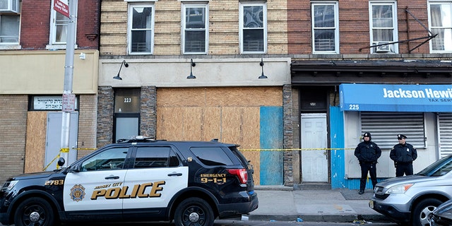 Police officers stand near the scene of a gunfight at a kosher supermarket in Jersey City, N.J., on Dec 12.