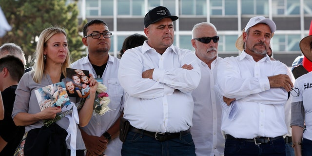 Adriana LeBaron, left, Julian LeBaron, center, and Adrian LeBaron, right, stand during a protest against the first year in office of López Obrador on Monday in Mexico City. The LeBaron's joined a protest to expresse anger and frustration over increasingly appalling incidents of violence, a stagnant economy and deepening political divisions in the country. (AP Photo/Ginnette Riquelme)