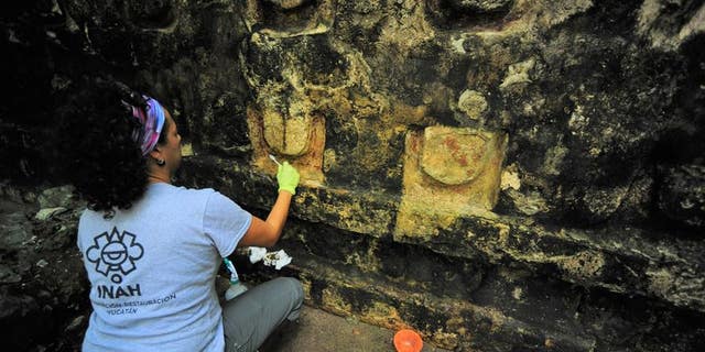 An archaeologist cleans a portion of the building found in Kuluba.