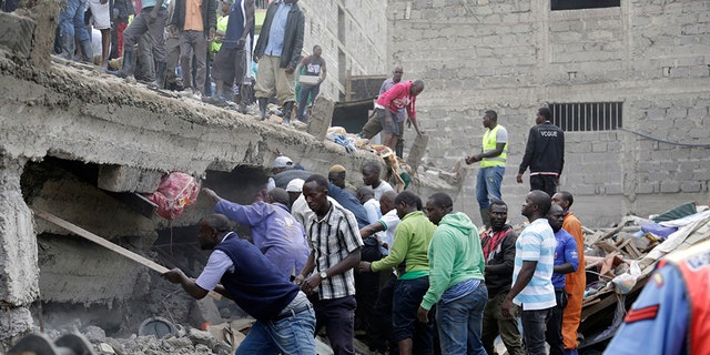 People at the scene of a collapsed building in in Tasia Embakasi, an east neighbourhood of Nairobi, Kenya on Friday Dec. 6, 2019. (Associated Press)