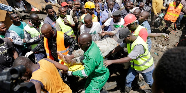 Rescue workers carry a person rescued from the rubble of a building that collapsed in Tasia Embakasi, an east neighbourhood of Nairobi, Kenya on Friday Dec. 6, 2019. (Associated Press)