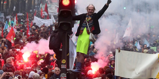 A man stands on a traffic light during a demonstration in Paris on Thursday. (AP)