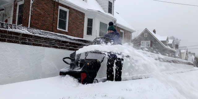 Doreen Goy, of Warwick, R.I., uses a snowblower to clear a sidewalk after a second round of snow struck the area, on Tuesday. Hospitals in Massachusetts reported a rash of snowblower-related hand injuries over a two-day period
