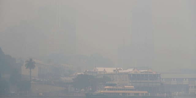A ferry sails on the harbor as thick smoke settles in Sydney, Australia, Tuesday, Dec. 10, 2019.